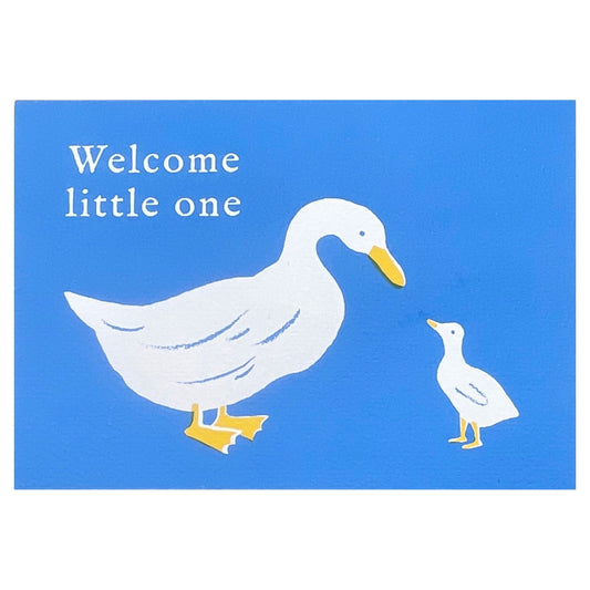 New baby greetings card, with a white duck and duckling on a blue background.  words " Welcome little one". Card by Ariana Martin