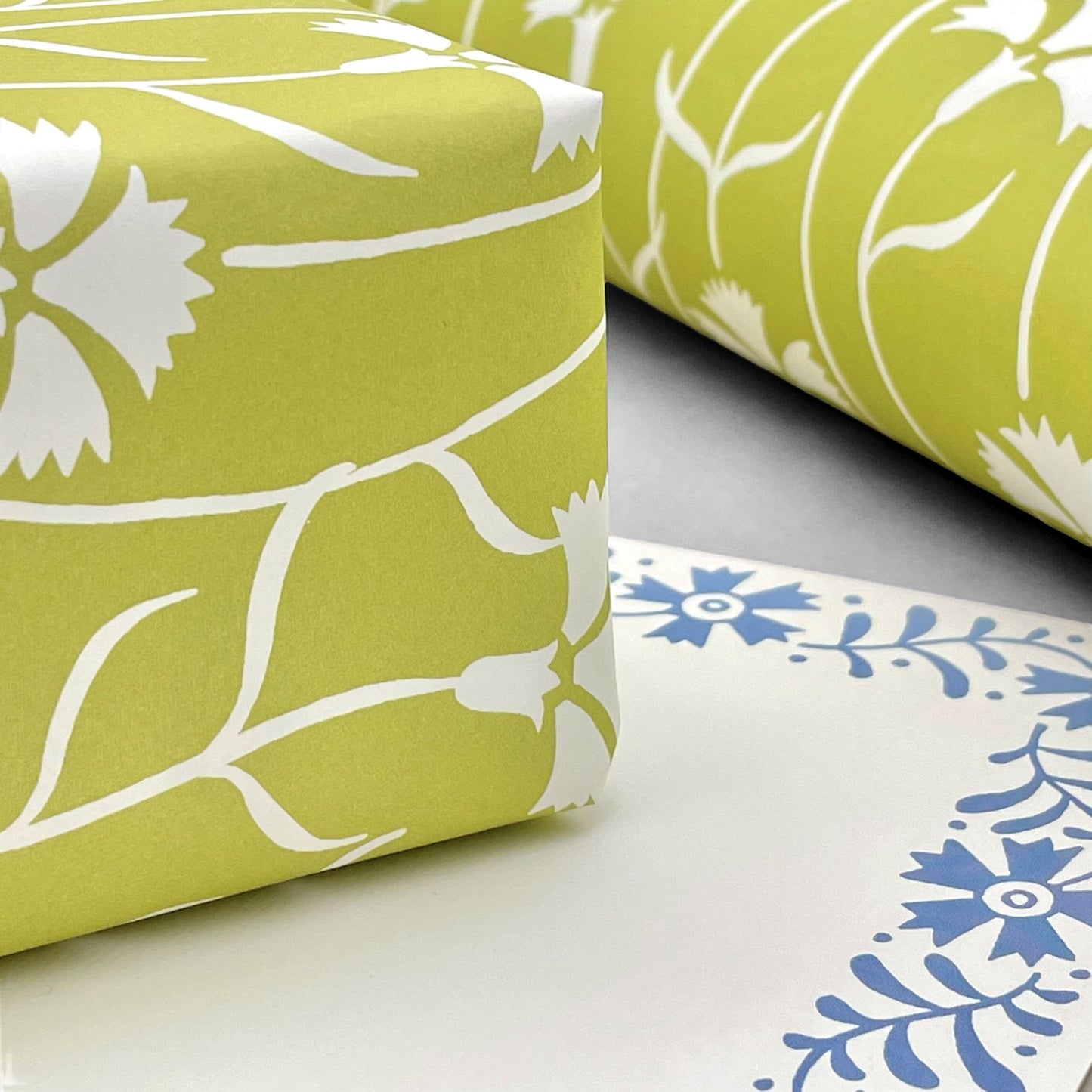 patterned paper, gift wrap with a white cornflower repeat pattern on soft lime green backdrop, by Ariana Martin