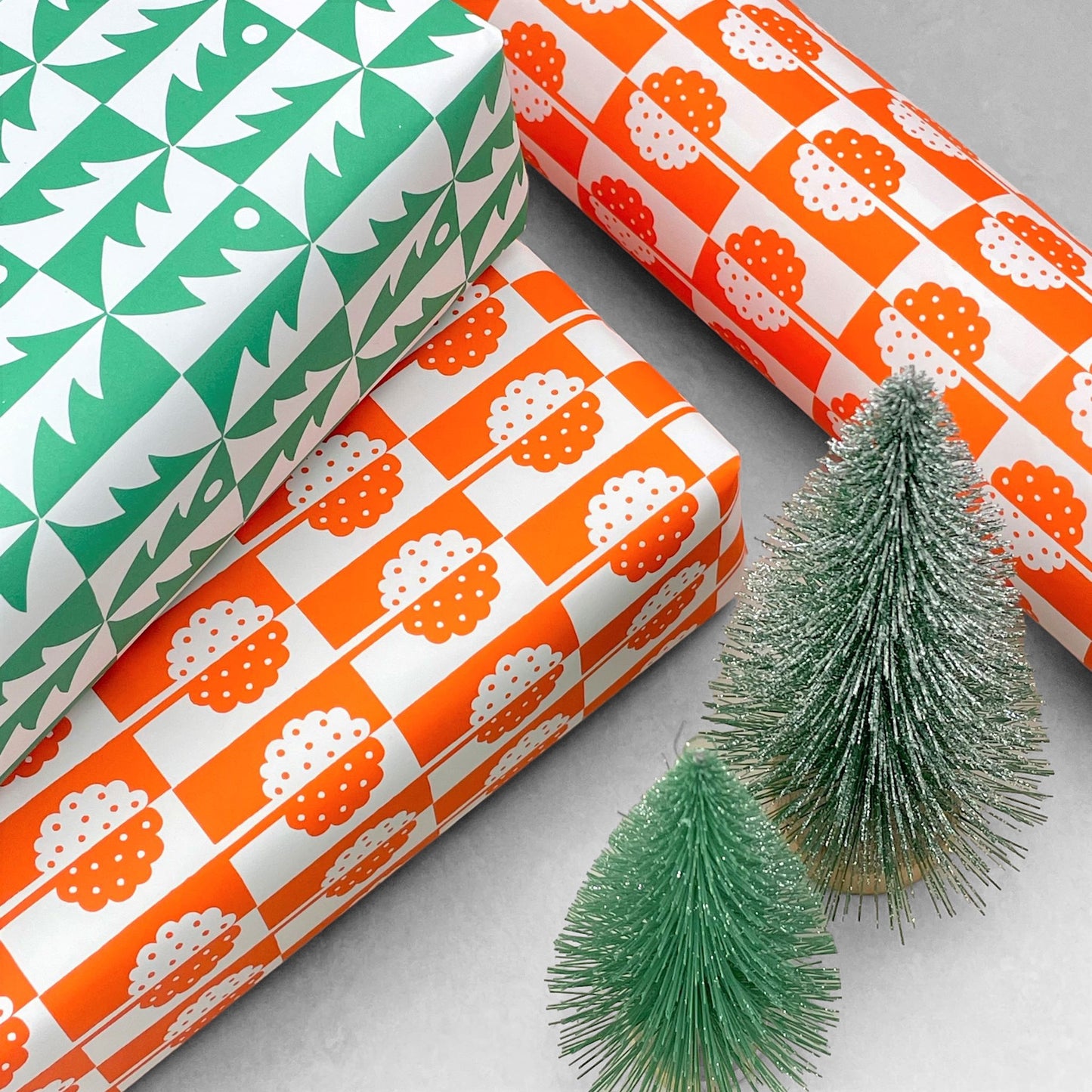 patterned paper, gift wrap, with all-over holly tree design in bright orange and white, by Ariana Martin