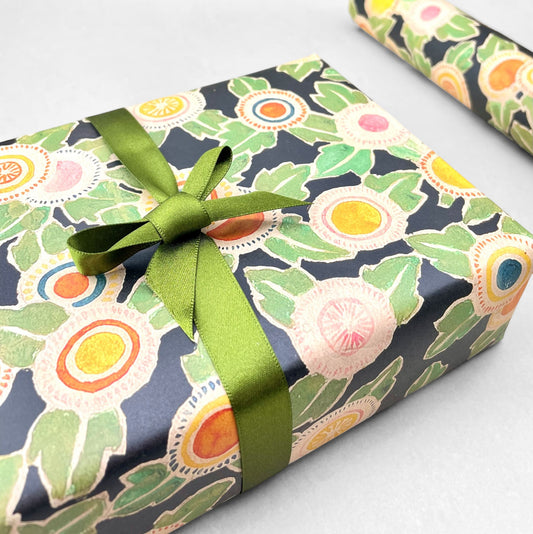 wrapping paper with green, pink, yellow and orange abstract floral repeat on black ground by Artisan Design. Design by Silver Studio