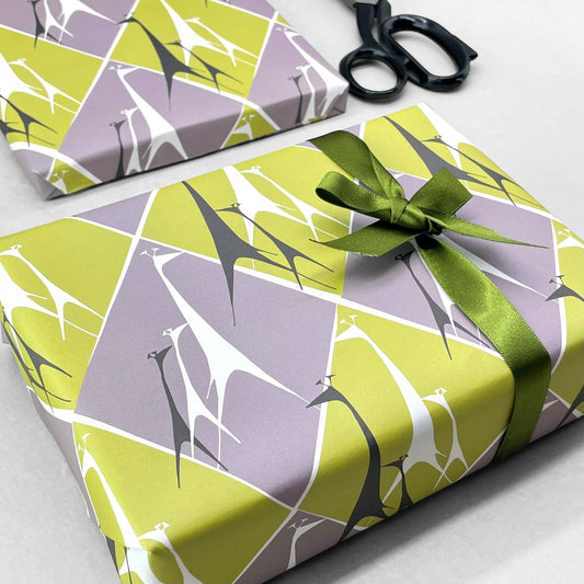 wrapping paper with stylised white and charcoal outline giraffes on a diamond backdrop of green and grey by Artisan Design