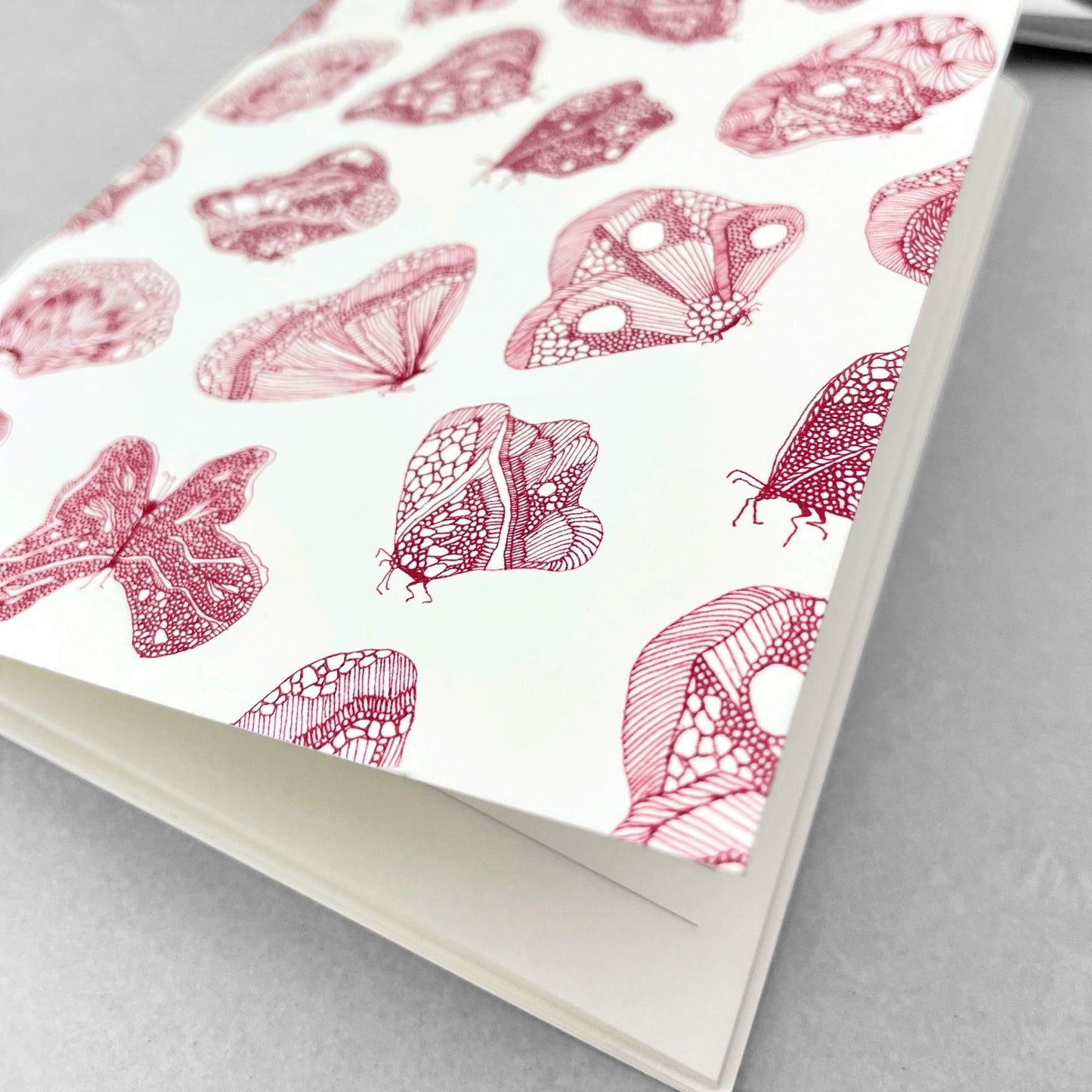 A5 slimline notebook with a delicate illustration of butterflies in burgundy on a ivory backdrop by Parisian brand Atelier Mouti