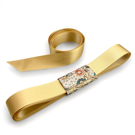 Satin ribbon 25mm wide and 5 metres long, presented with a patterned paper band. colour - honey gold