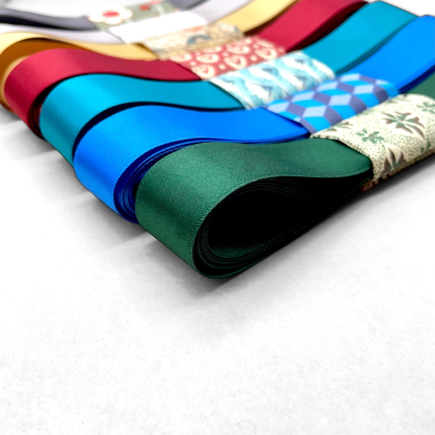 Satin ribbon 25mm wide and 5 metres long, presented with a patterned paper band. colour - forest green