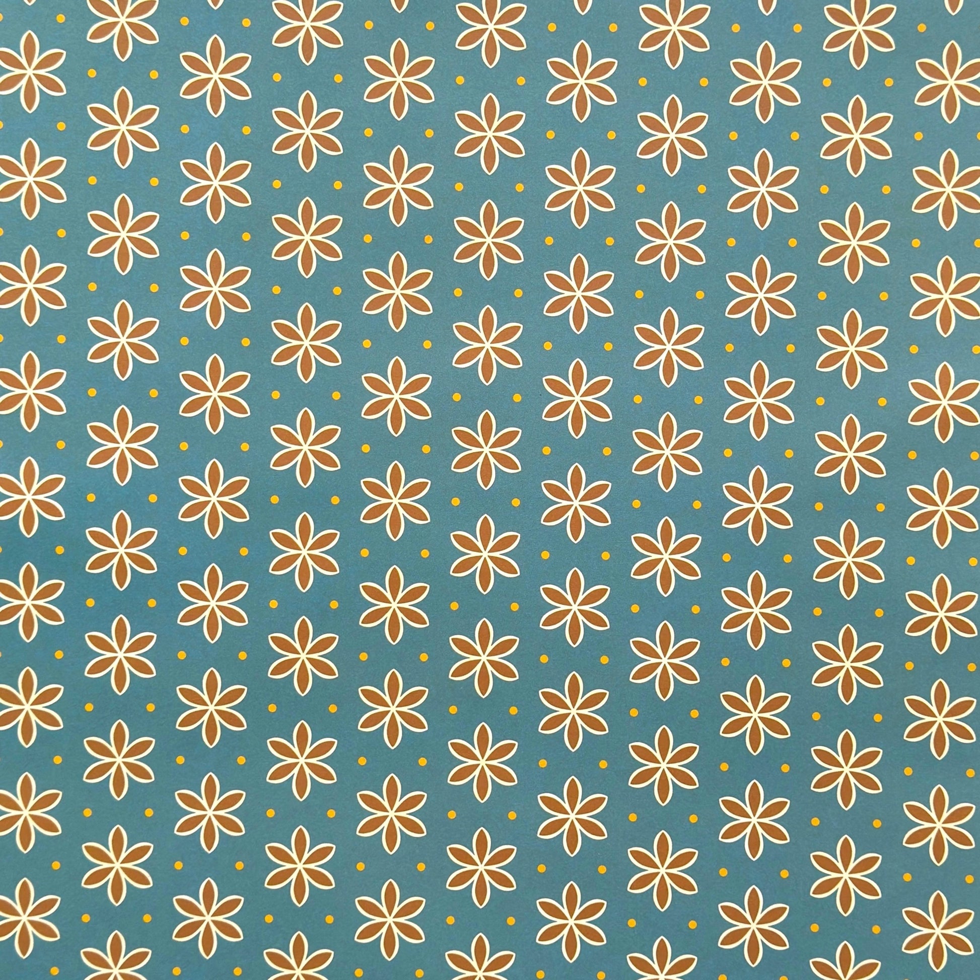 a sheet of wrapping paper with a repeat pattern of stylised brown flowers on a teal green background