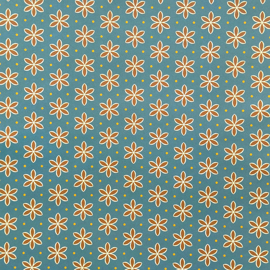 a sheet of wrapping paper with a repeat pattern of stylised brown flowers on a teal green background