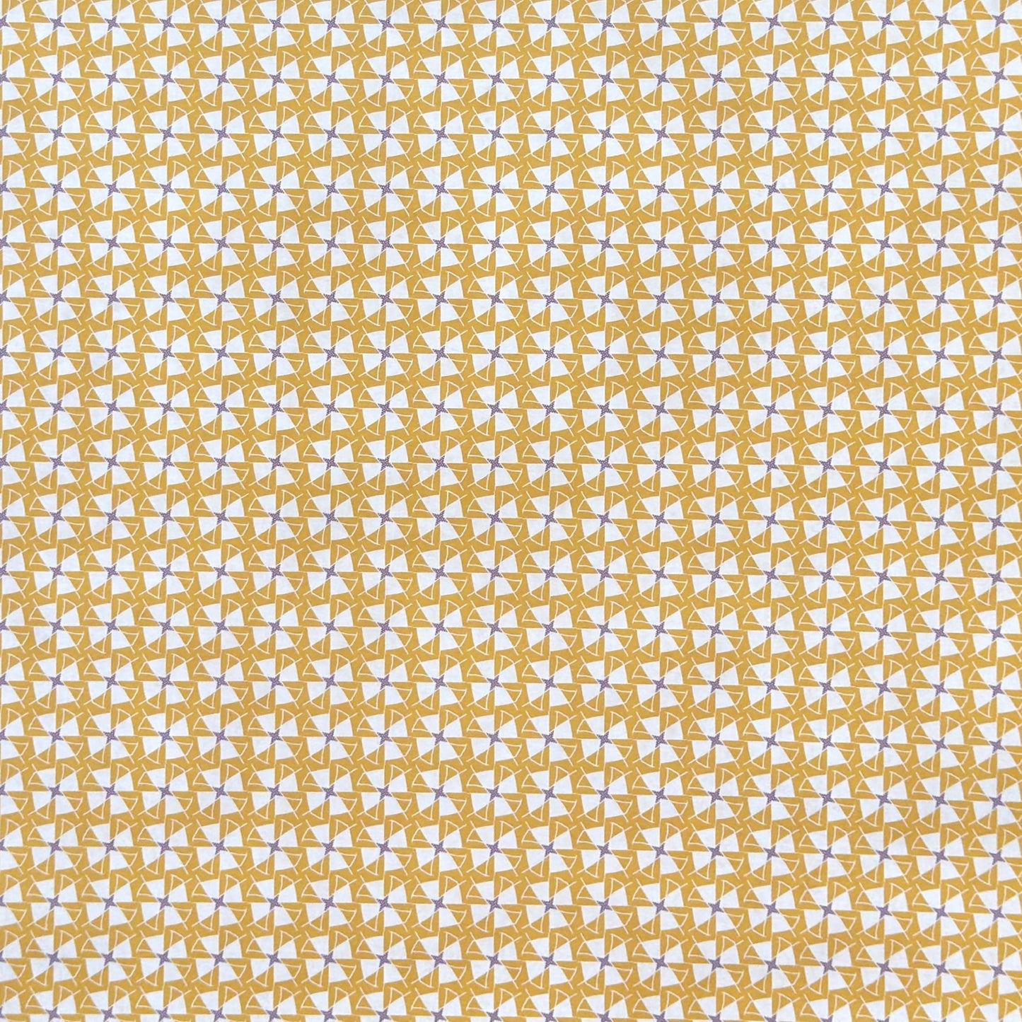 a sheet of wrapping paper with a geometric star pattern in white and purple on mustard yellow background
