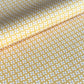 a sheet of wrapping paper with a geometric star pattern in white and purple on mustard yellow background