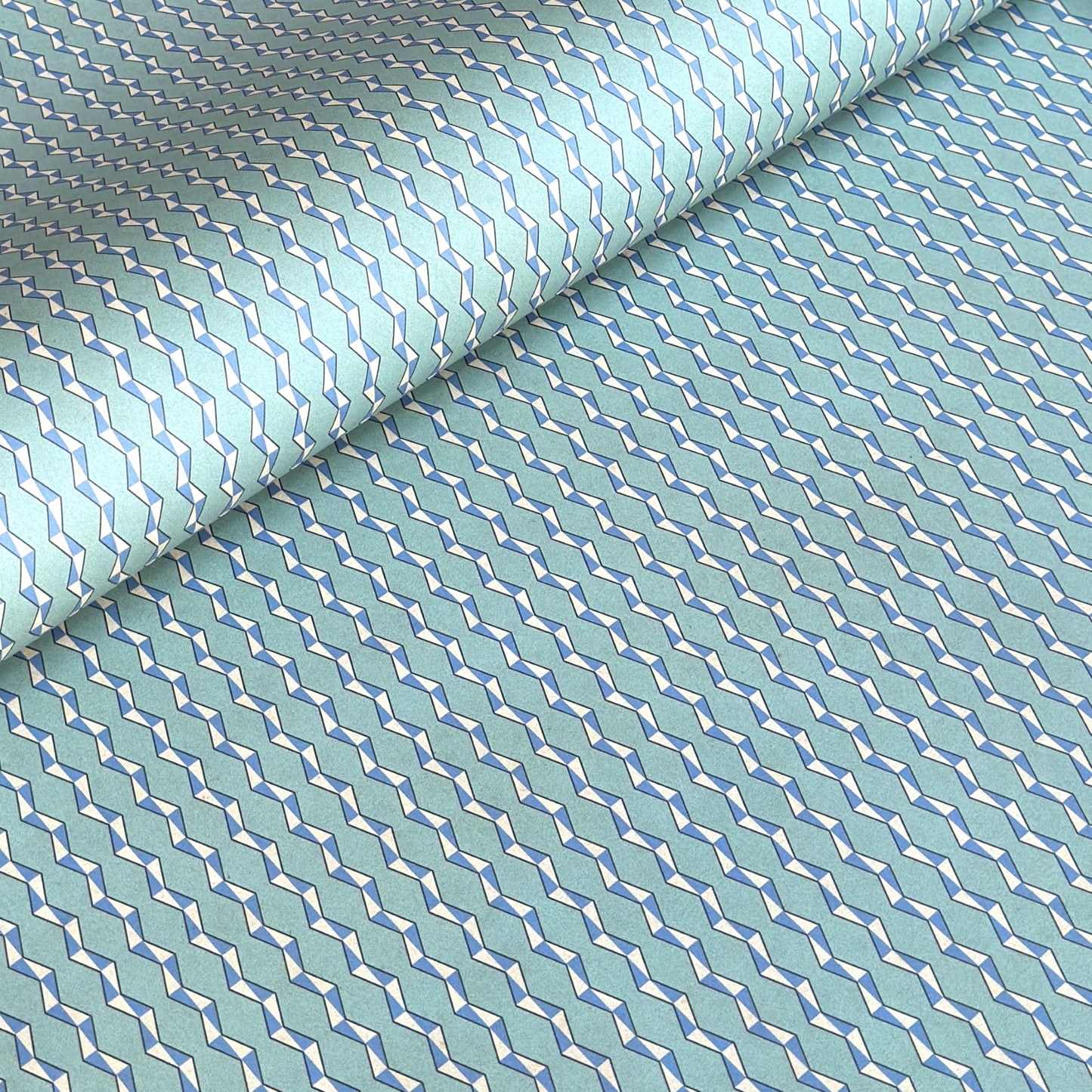 wrapping paper with a geometric zigzag design in aqua, blue and white