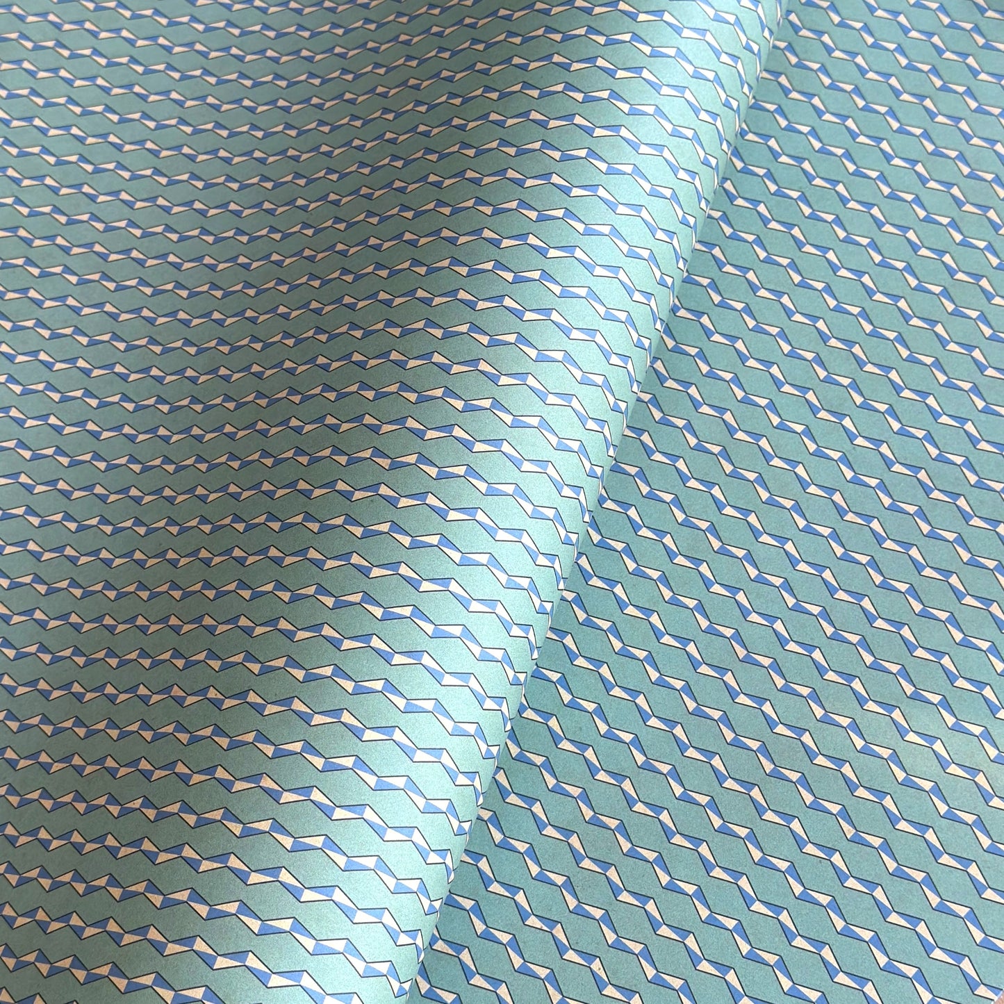 wrapping paper with a geometric zigzag design in aqua, blue and white