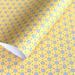 a sheet of wrapping paper with a yellow background and colorful blue circles pattern