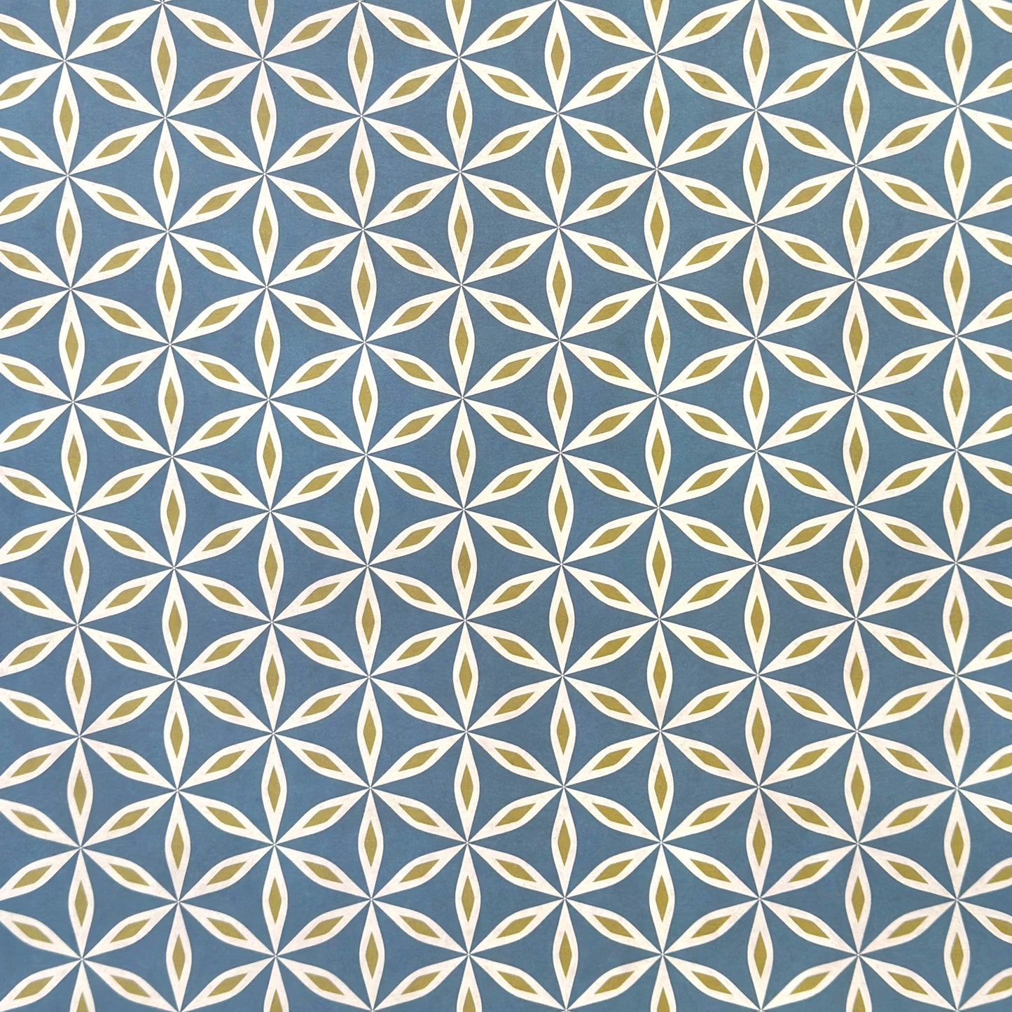 geometric wrapping paper with a star flower pattern in white and lime on teal