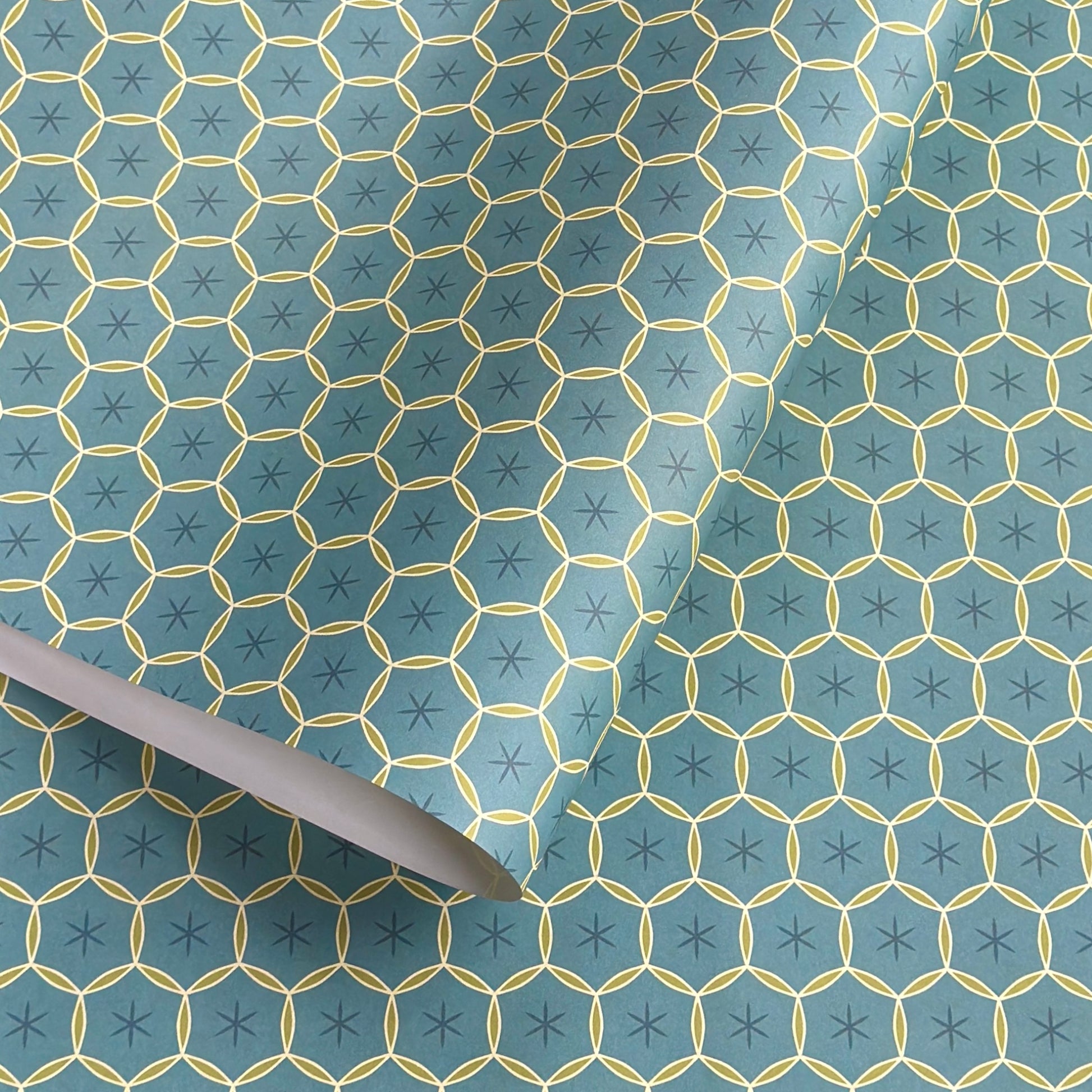 abstract wrapping paper with a geometric circle pattern with a star in the middle in teal blue and lime green