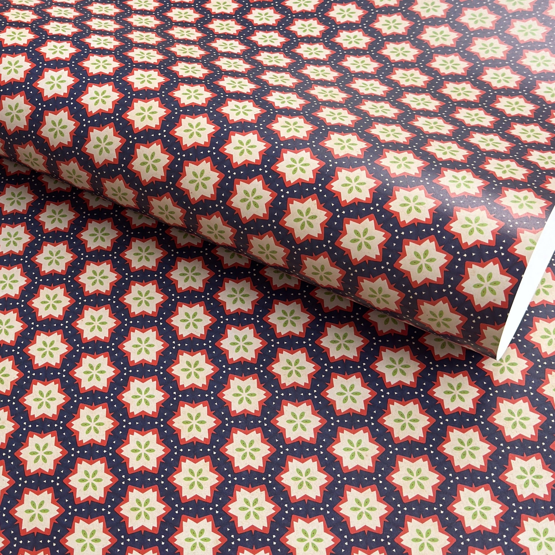 Patterned paper with red, green, and white stars on a blue background