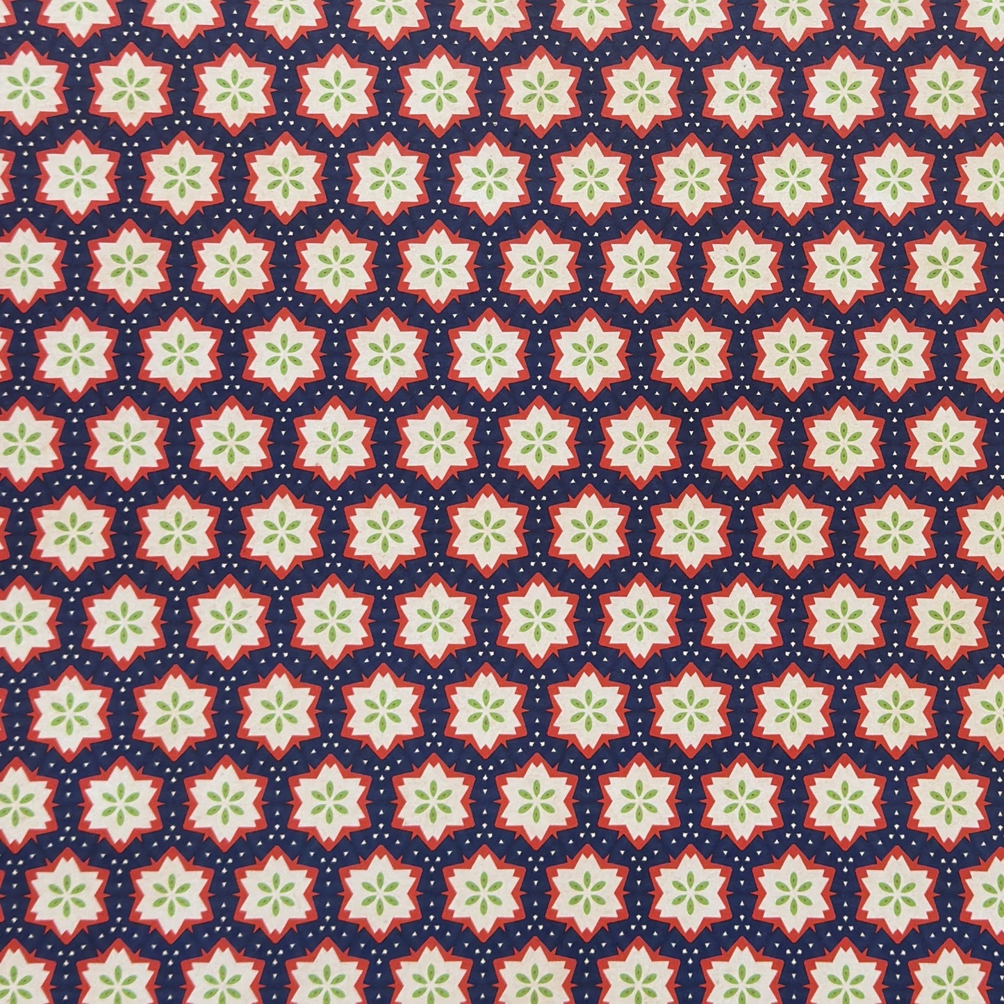 Patterned paper with red, green, and white stars on a blue background