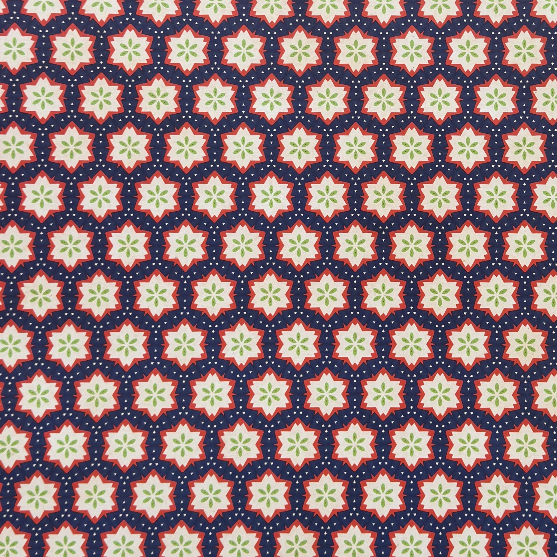 Patterned paper with red, green, and white stars on a blue background