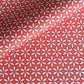 a sheet of wrapping paper with a floral geometric design in white and navy on red