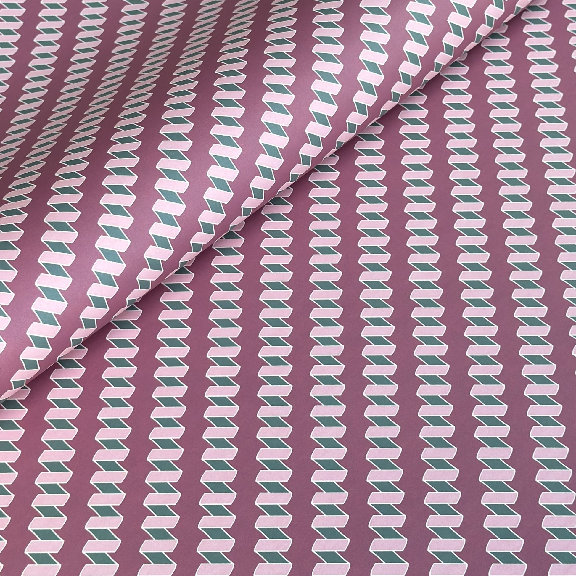 a sheet of wrapping paper with a zigzag pattern in lilac and green on a purple background