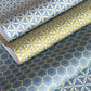 Three sheets of patterned paper with geometric designs on a blue background.