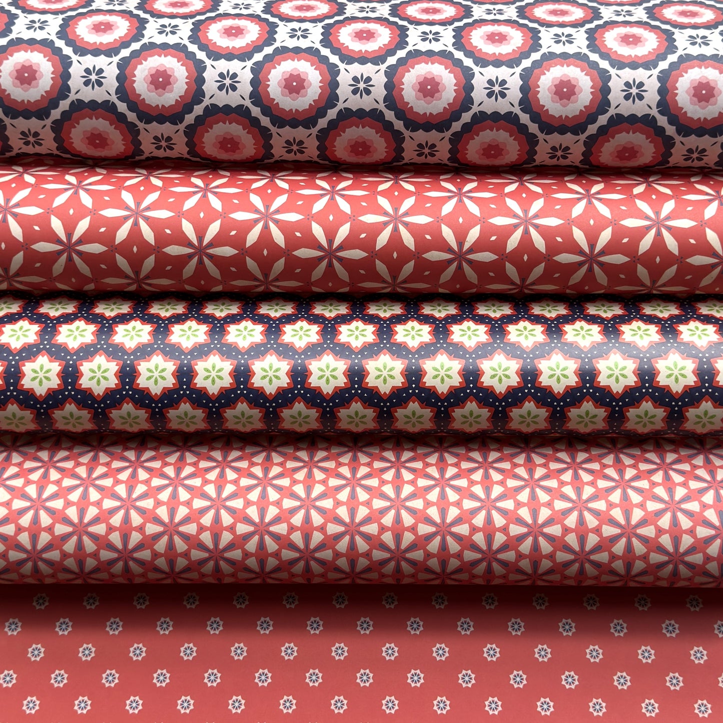 Stack of rolls of wrapping paper with various geometric patterns