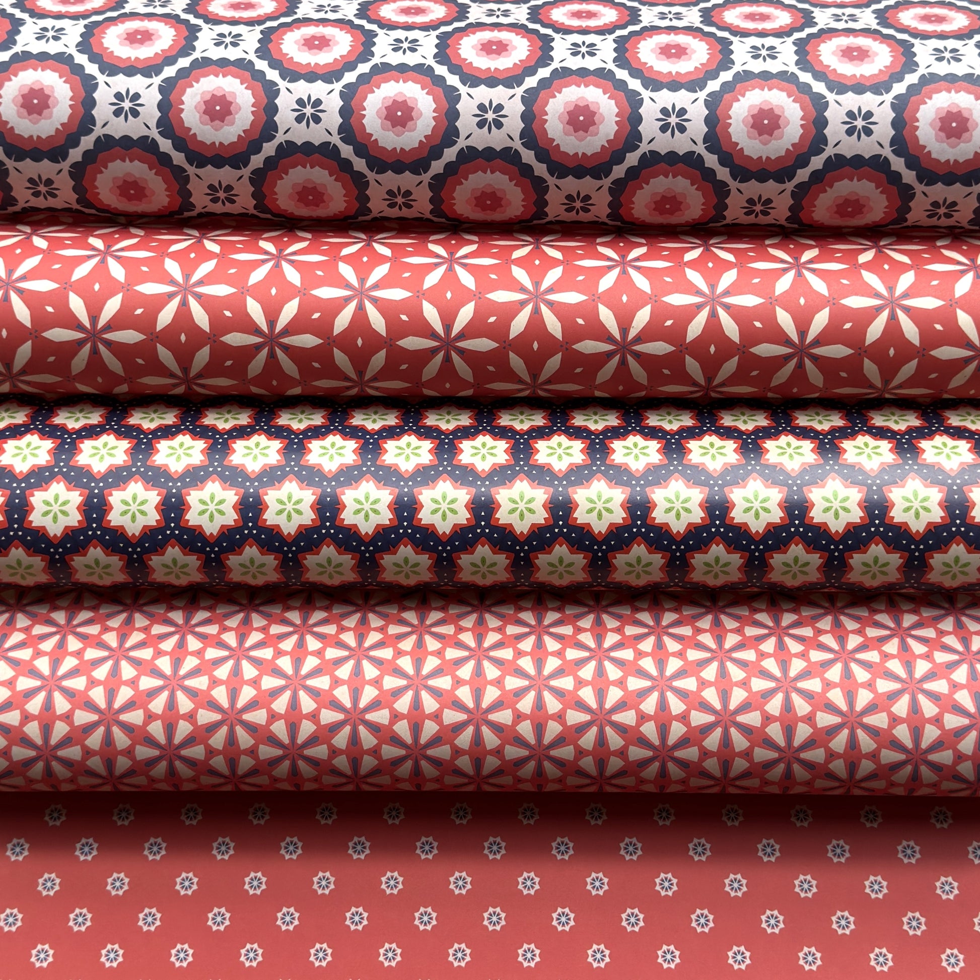 Stack of rolls of wrapping paper with various geometric patterns