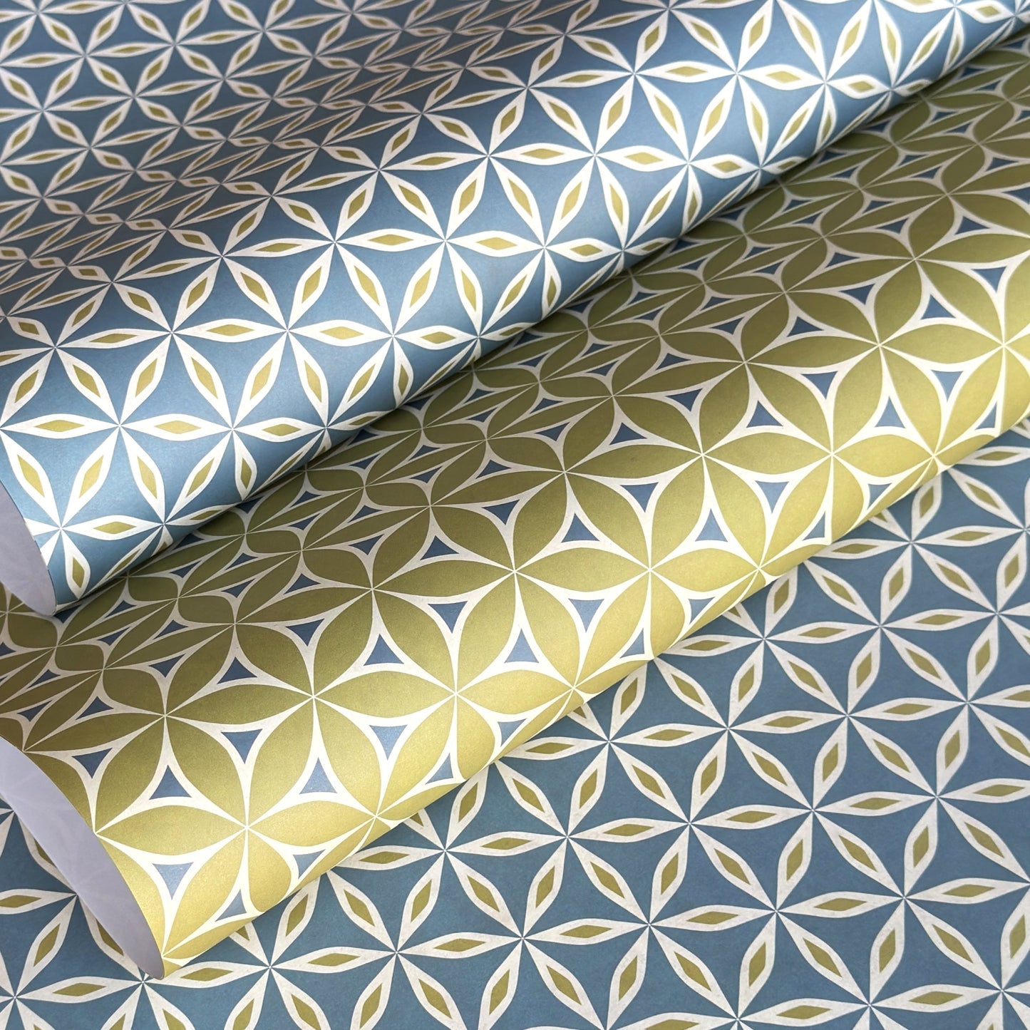 two sheets of geometric wrapping paper in coordinating patterns in lime and teal
