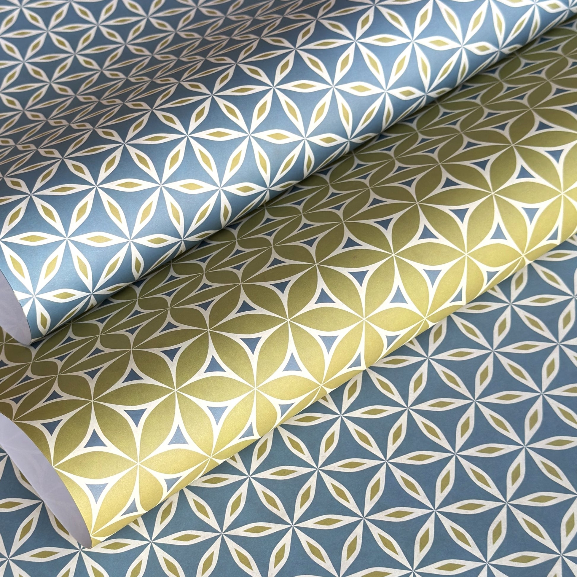 two sheets of geometric wrapping paper in coordinating patterns in lime and teal