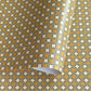 Patterned wrapping paper with geometric design in yellow, white, and green.