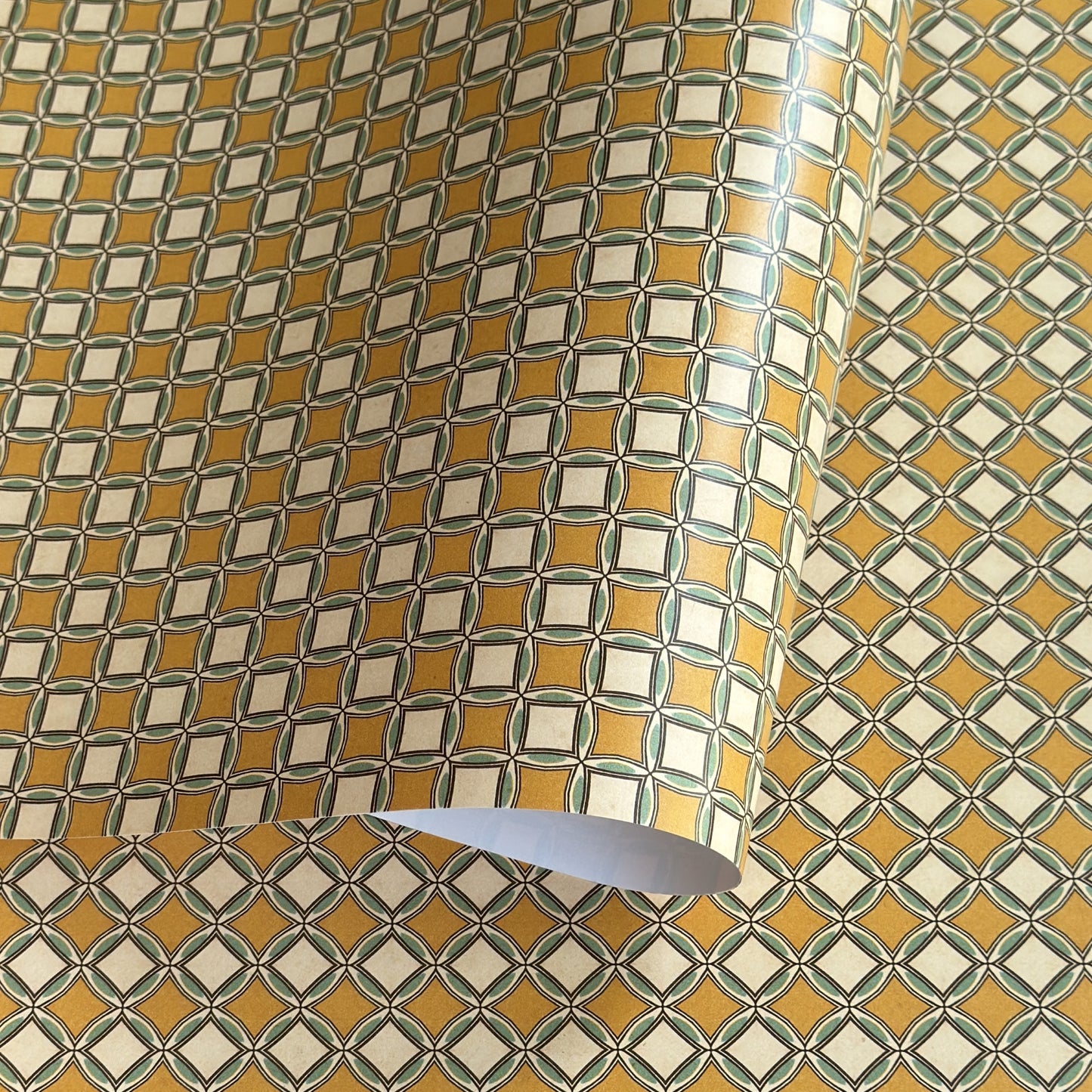 Patterned wrapping paper with geometric design in yellow, white, and green.