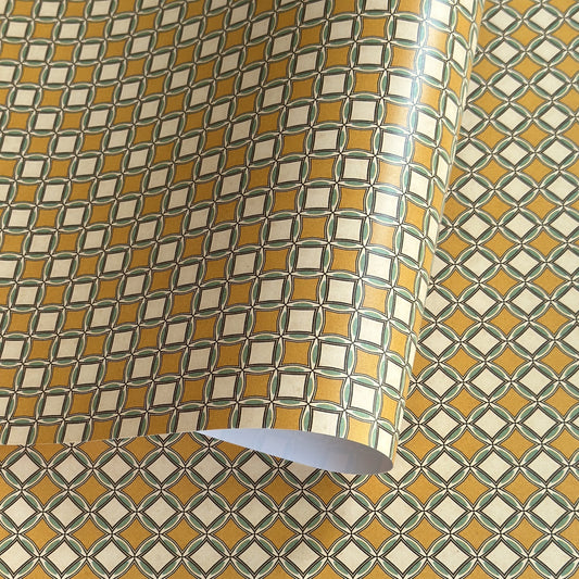 Patterned wrapping paper with geometric design in yellow, white, and green.