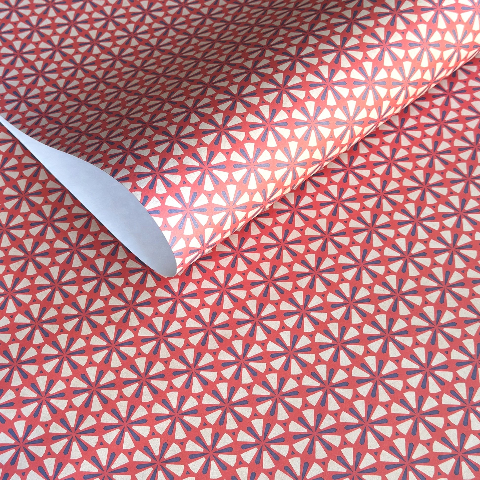 a sheet of geometric paper in red, purple and white