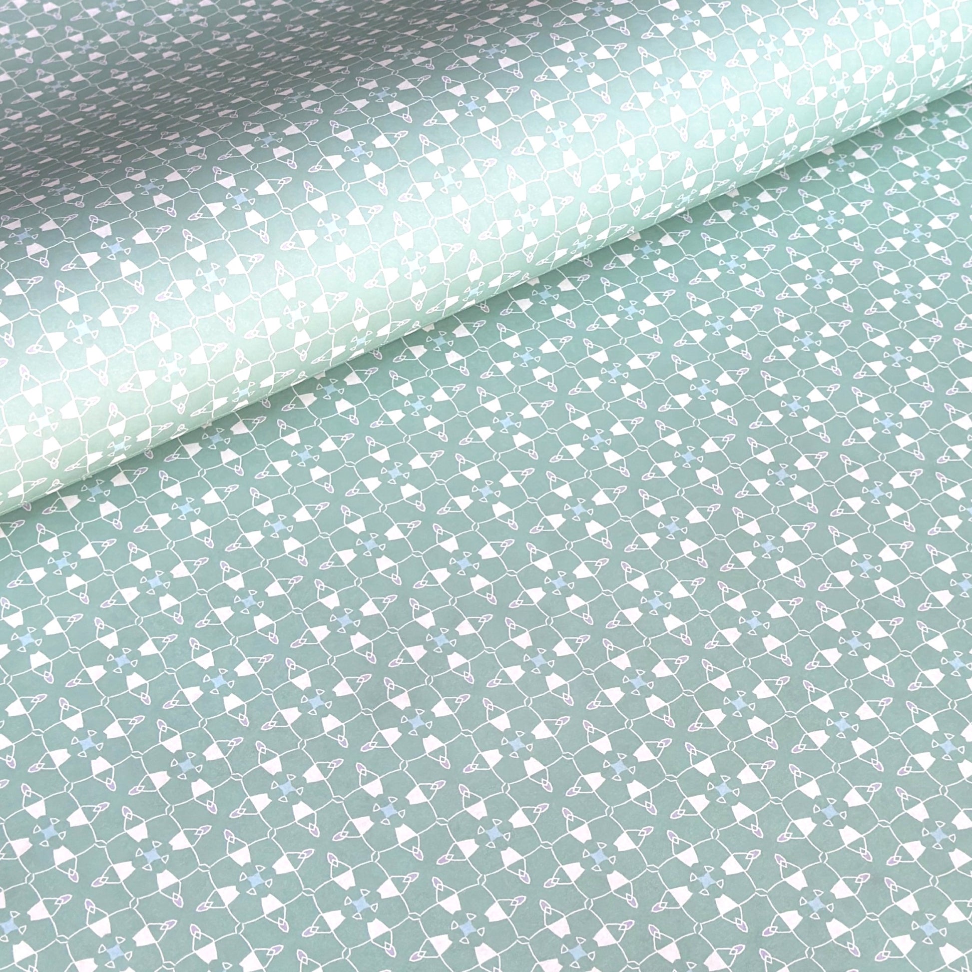 a sheet of wrapping paper with a geometric design on aqua backdrop