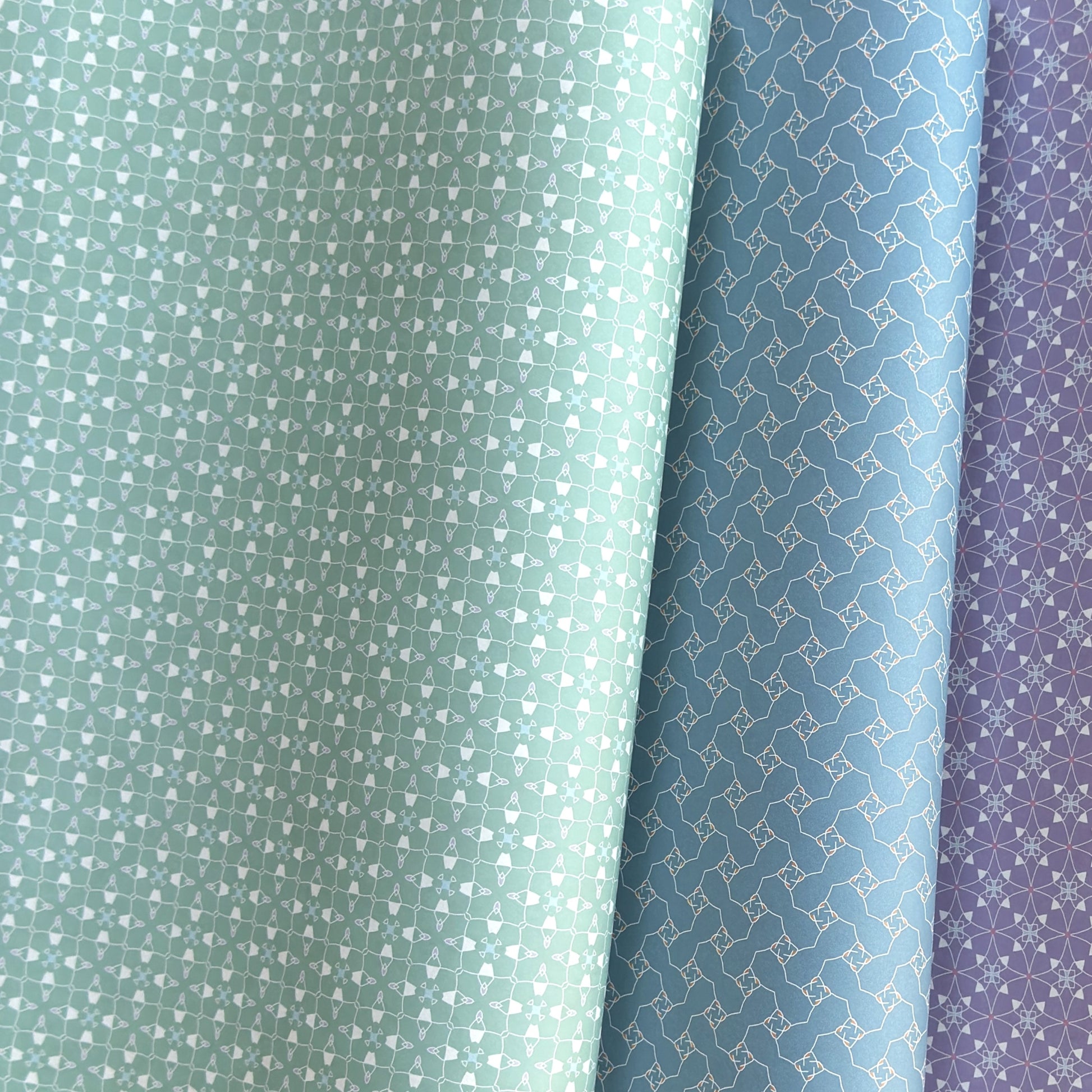 Three wrapping papers in green, blue, and purple with geometric patterns.