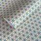 wrapping paper with a geometric pattern in green and yellow on beige