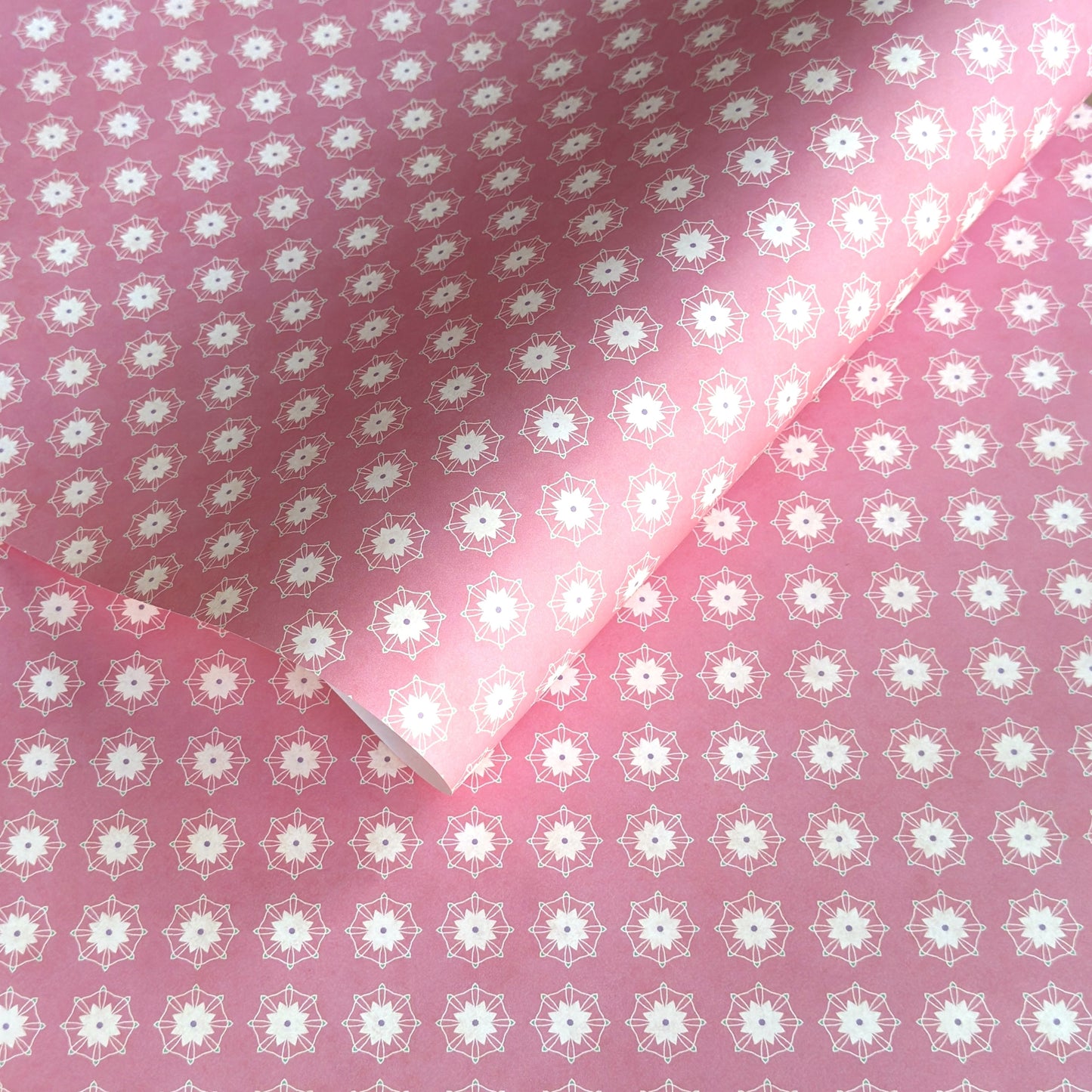 Pink wrapping paper with white floral geometric pattern