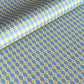 wrapping paper with a geometric pattern of lines of little lime green diamonds on a teal