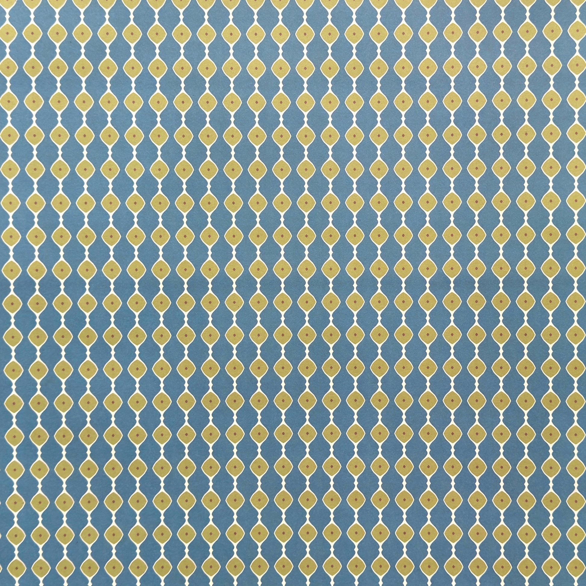 wrapping paper with a geometric pattern of lines of little lime green diamonds on a teal