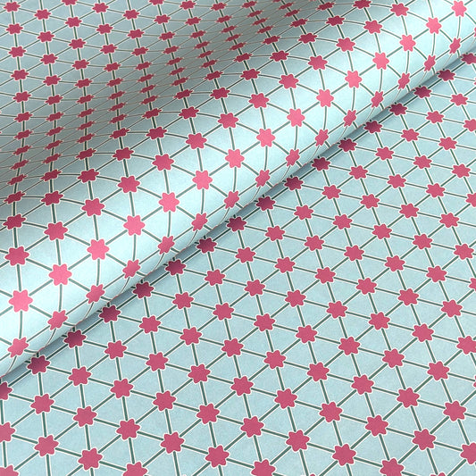 Patterned paper with pink floral shapes on a light blue background
