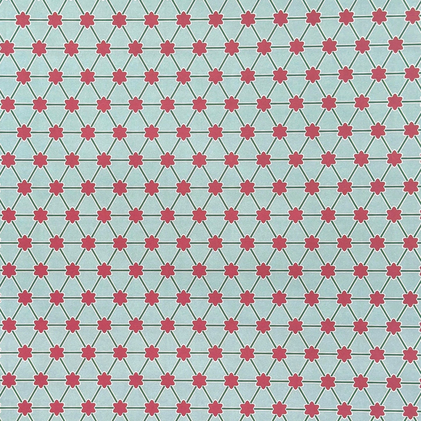 Patterned paper with pink floral shapes on a light blue background