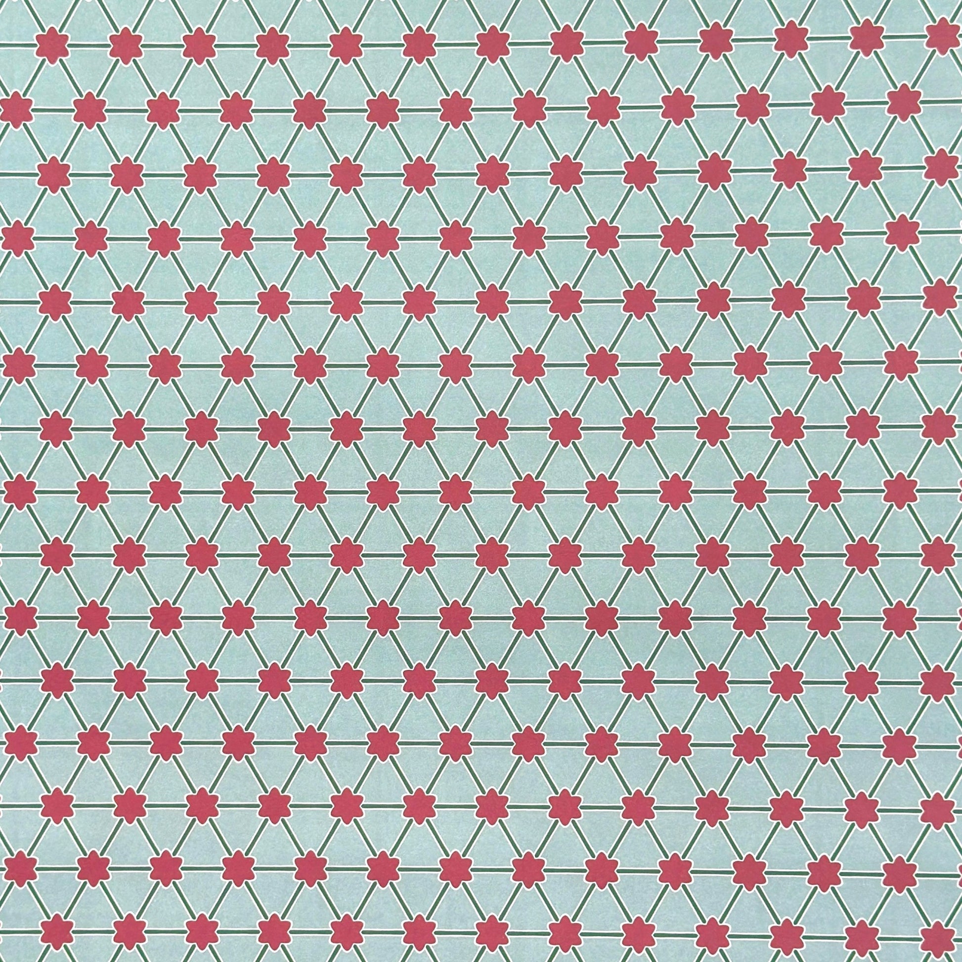 Patterned paper with pink floral shapes on a light blue background
