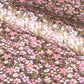 Cherry blossom patterned wrapping paper in pink, white and yellow on brown background