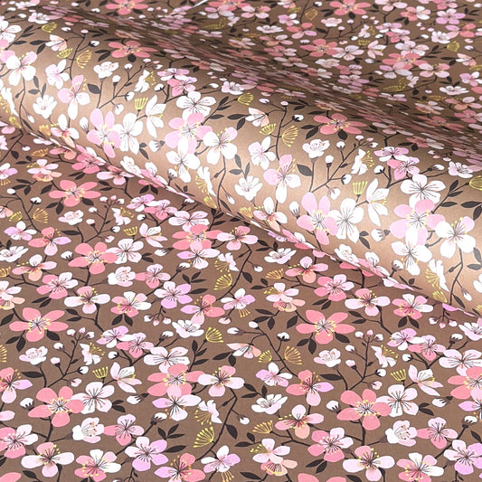 Cherry blossom patterned wrapping paper in pink, white and yellow on brown background