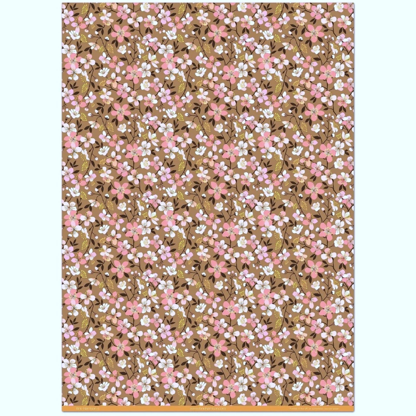 Cherry blossom patterned wrapping paper in pink, white and yellow on brown background