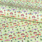 A sheet of wrapping paper with a pattern of colourful butterflies and insects on a light green background