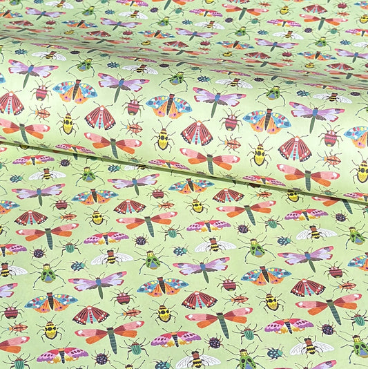 A sheet of wrapping paper with a pattern of colourful butterflies and insects on a light green background