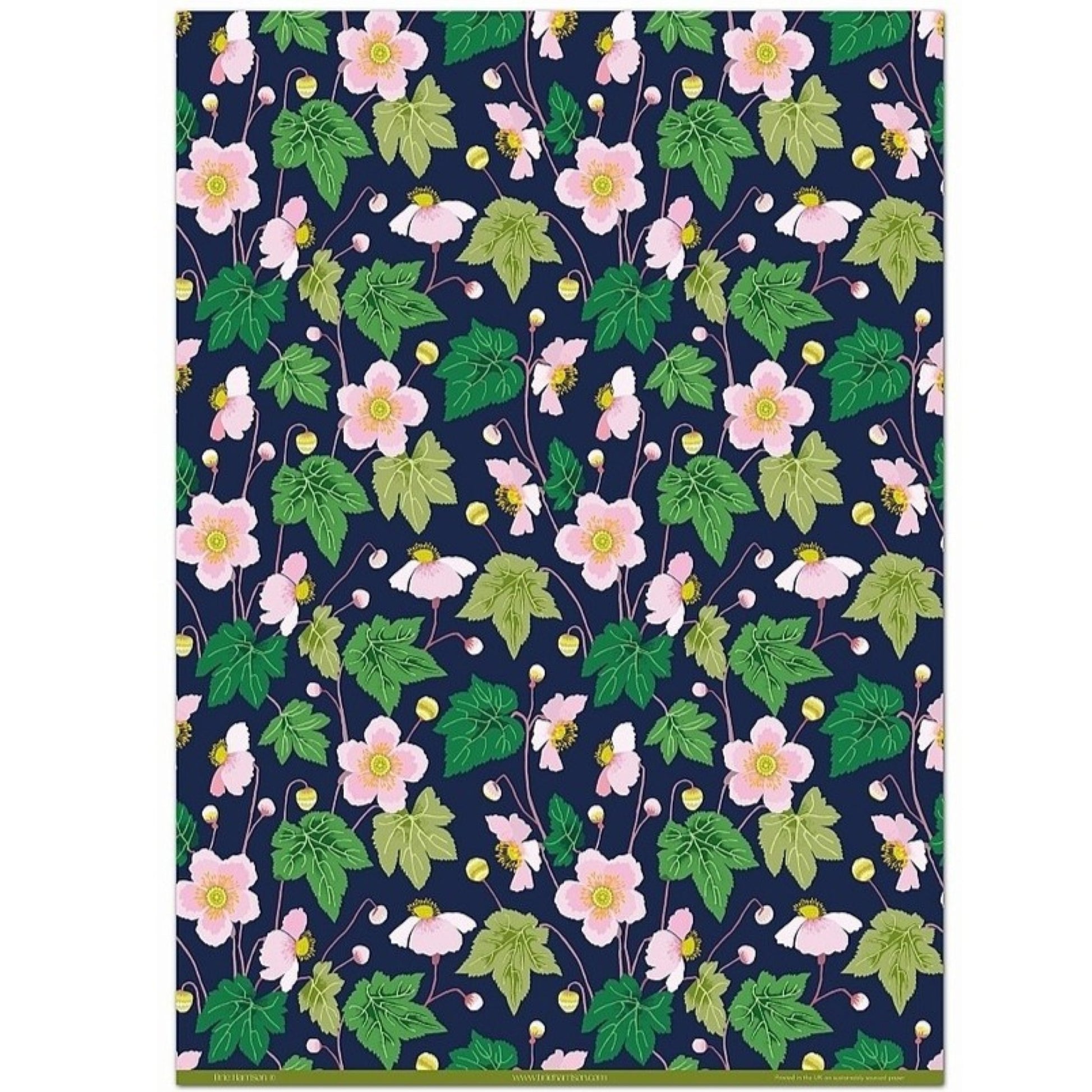 a sheet of wrapping paper with a dark indigo background and pink japanese anemone flowers and green foliage
