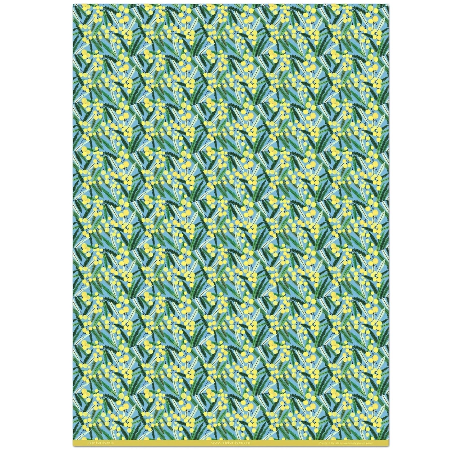 a sheet of wrapping paper with a pattern of yellow mimosa flowers and green leaves on a blue background