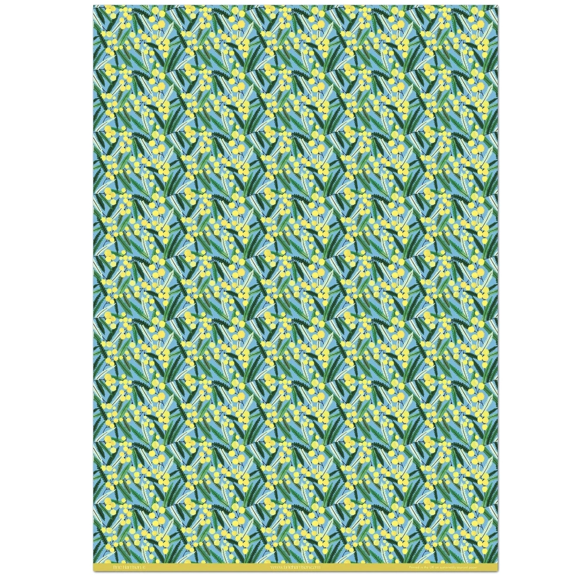 a sheet of wrapping paper with a pattern of yellow mimosa flowers and green leaves on a blue background