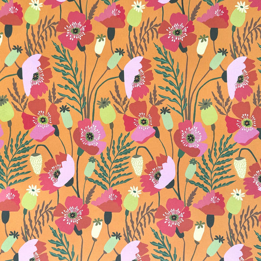 a sheet of wrapping paper with a pattern of stylised pink poppies with green foliage on an orange background