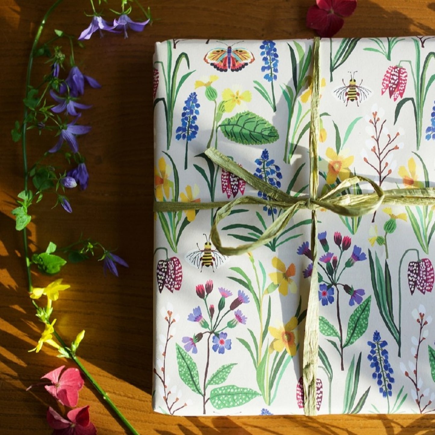 Patterned paper with colourful spring flowers and bees on a ivory background